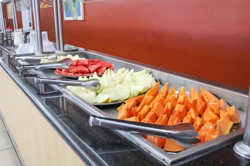 a buffet line with different types of cheese and fruit at VOA Plazza Hotel in Águas de Lindóia