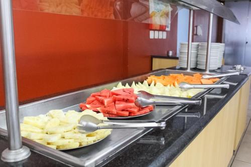 a buffet line with plates of fruits and vegetables at VOA Plazza Hotel in Águas de Lindóia