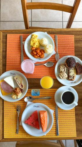 a table with plates of breakfast food on it at VOA Plazza Hotel in Águas de Lindóia