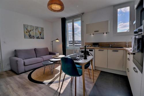 une cuisine et un salon avec une table et un canapé dans l'établissement Appartement 