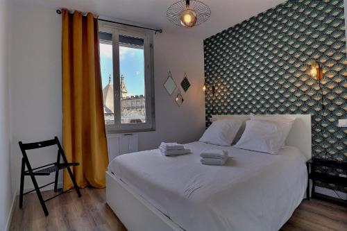 une chambre avec un grand lit blanc avec une fenêtre dans l'établissement Appartement "PANNA" centre ville de VITRÉ, à Vitré