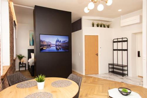 a living room with a table and a tv on a wall at Keskväljaku apartment - with sauna and AC in Võru