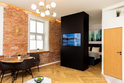 a living room with a brick wall and a bedroom at Keskväljaku apartment - with sauna and AC in Võru