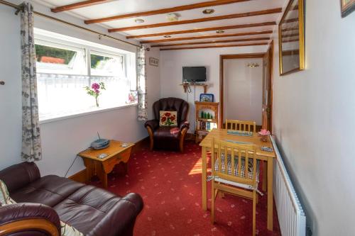 a living room with a couch and a table at Rosebud cottage Romantic cottage for a couple in Fishguard