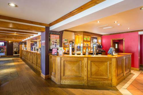 a bar in a restaurant with wooden cabinets at Charter Hotel Bournemouth in Bournemouth
