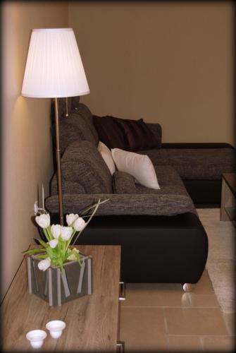 a living room with a couch and a table with a lamp at Roudenhaff Guestfarm in Echternach
