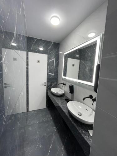 a bathroom with two sinks and a mirror and a shower at Altin Palace in Komrat