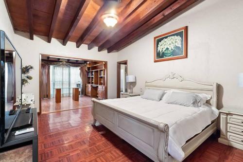 1 dormitorio con 1 cama grande y TV en +MS +Casa Tequis +Hermoso Jardín, en Tequisquiapan