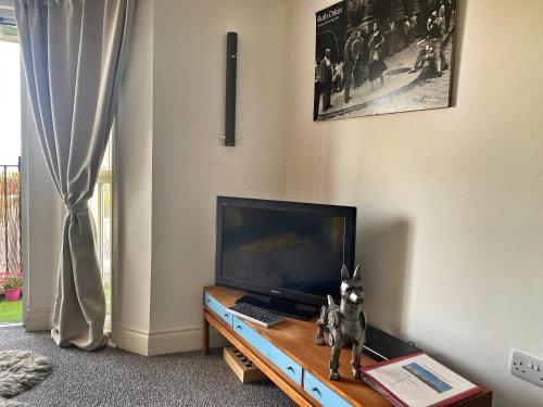 a dog statue sitting on a table in front of a television at Sea House in Hastings