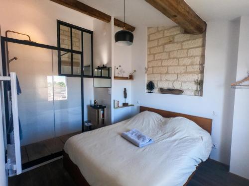a bedroom with a white bed and a brick wall at Laurène 1 - Montpellier centre - Gare St Roch - HH in Montpellier