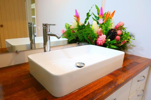 a white sink with flowers on a counter in a bathroom at Fare Omoe in Fare