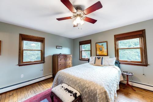 Higgins Lodge في Warren: غرفة نوم بسرير ومروحة سقف