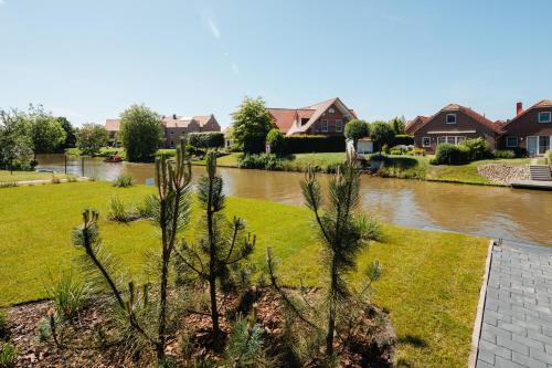 a view of a river with houses and trees at Küsten Suite West seitliche Wasserlage, 1 Balkon, 90qm in Greetsiel