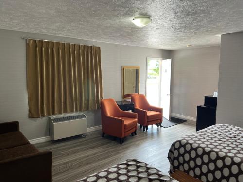 a hotel room with two chairs and a bed at Wiarton Willys Inn in Wiarton