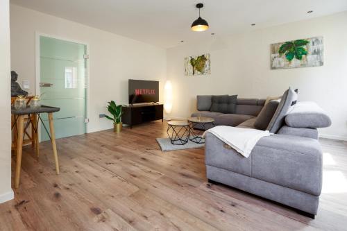 a living room with a couch and a table at MoselloLodge, Luxus Ferienhaus mit großer Dachterrasse, Top Ausstattung, Waschmaschine, Netflix in Senheim