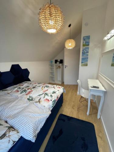 a bedroom with a bed and a table and two lights at Blue Wave Garden in Dziwnówek