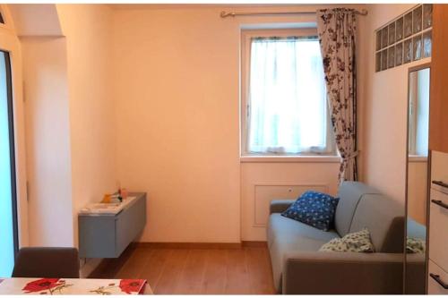a living room with a couch and a window at Appartamento Carta da Zucchero in Riva del Garda