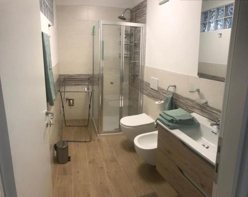 a bathroom with a shower and a toilet and a sink at Appartamento Carta da Zucchero in Riva del Garda