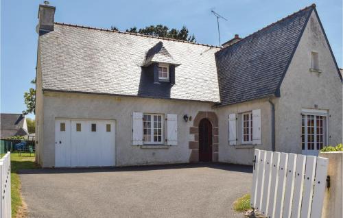 une maison avec une clôture blanche devant elle dans l'établissement 3 Bedroom Nice Home In Ploumilliau, à Ploumilliau