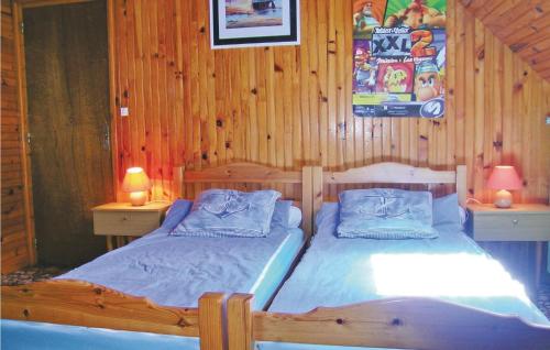PloumilliauにあるBeautiful Home In Ploumilliau With Kitchenのベッド2台 木製の壁の部屋