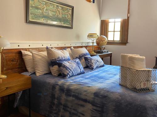 sypialnia z łóżkiem z niebieską pościelą i poduszkami w obiekcie Buenos Aires Rowing Club w mieście Tigre