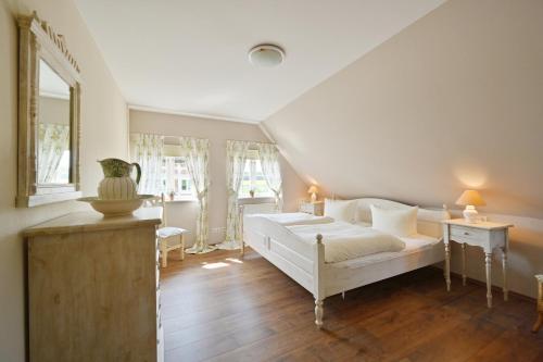 a bedroom with a white bed in a room at Landhaus Vilmnitz - Wohnung 10 in Vilmnitz