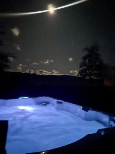 a jacuzzi tub in the snow at night at Cosy Cottage in the Vines in Waipara