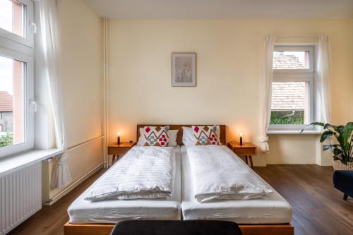 a bed in a room with two windows at Nähe Europa Park! Exklusive Ferienwohnung mit 140 qm! in Kippenheim