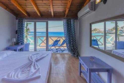 Schlafzimmer mit einem Bett und Meerblick in der Unterkunft DEJA BLUE Maisonette ll in Kokkari