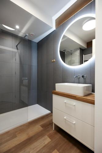 a bathroom with a sink and a mirror at Villa Park Apartament in Ostróda