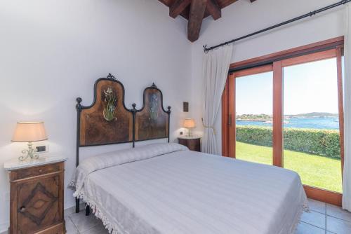 - une chambre avec un lit et une grande fenêtre dans l'établissement S'abba e sa Pedra, à Golfo Aranci