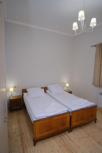 a bedroom with a bed with white sheets and two lamps at Toon 55 Boutique Hotel in Gyumri