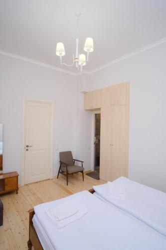 a white room with two beds and a chair at Toon 55 Boutique Hotel in Gyumri