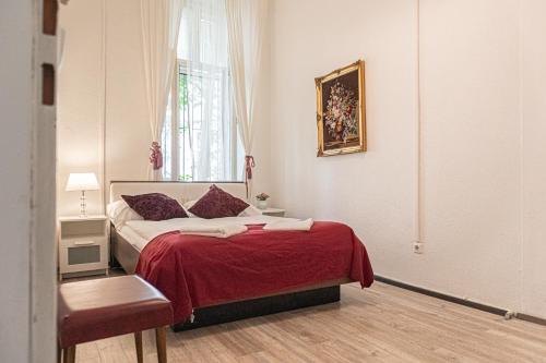 ein Schlafzimmer mit einem Bett mit einer roten Decke und einem Fenster in der Unterkunft Timeless Red 1BR Apartment - Great for Longstays in Wien