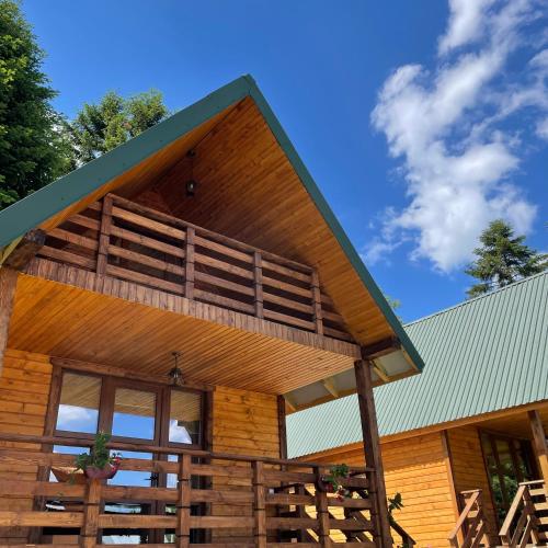 a large wooden cabin with a large balcony at Hill Hut in Myta