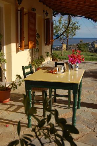 a table with flowers on it in front of a house at Panorama Apartments updated with infinity pool in Agios Nikolaos