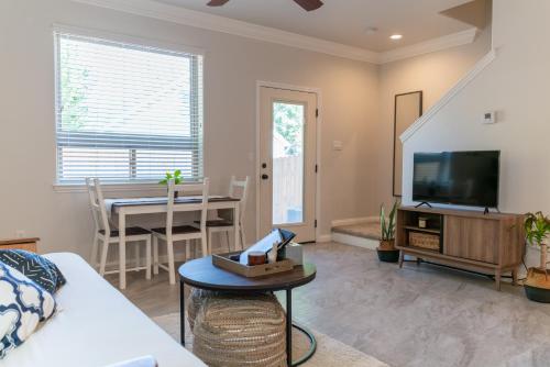 ein Wohnzimmer mit einer Couch, einem Fernseher und einem Tisch in der Unterkunft Boho Townhome in Carson City 10 Mins From Downtown, 30 Mins To Lake Tahoe in Carson City
