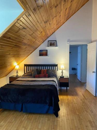 a bedroom with a large bed with a wooden ceiling at Loft apartment in Kensington in Kensington