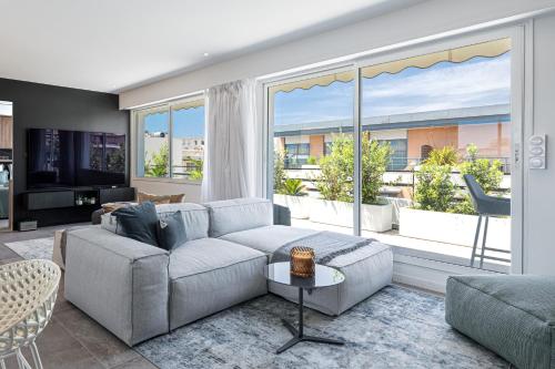 un salon avec un canapé et une grande fenêtre dans l'établissement LUXURIOUS PENTHOUSE ROOFTOP MARTINEZ CROISETTE, à Cannes