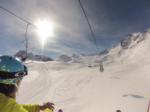 a person riding a ski lift on a snow covered mountain at Hotel Garni Pegrà in Ponte di Legno