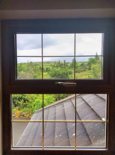 a window with a view of a wooden deck at Glenn Eireann House in Cushendun