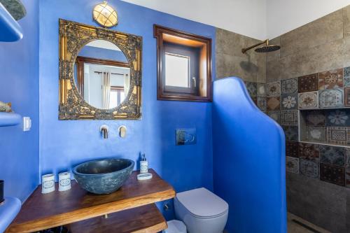 Baño azul con lavabo y espejo en Villa Driades, en Skopelos Town