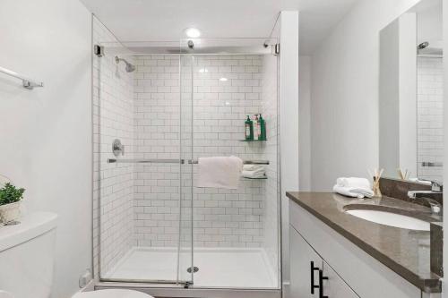 bagno bianco con doccia e lavandino di Modern & Vibrant Uptown Studio close to Shops - Wilson 401 a Chicago
