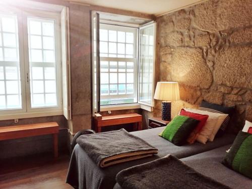 a bedroom with a bed and a stone wall at No Porto in Porto