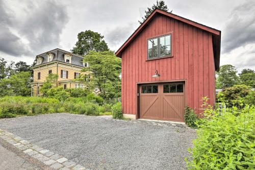 a red barn with a garage in front of a house at Barn-Like Studio Suite with Flowering Garden! in Titusville
