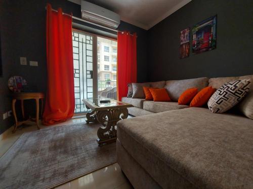 a living room with a couch and red curtains at Trendy House in Badr