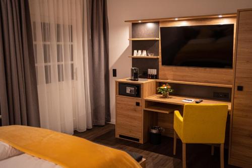 um quarto de hotel com uma secretária e uma televisão em Landgasthof Lehmsiek em Haby