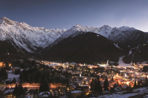 a view of a town with snow covered mountains at Hotel Garni Pegrà in Ponte di Legno