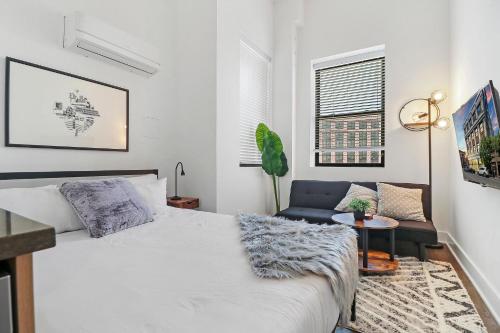 una camera bianca con un letto e un divano di Modern & Vibrant Uptown Studio close to Shops - Wilson 401 a Chicago