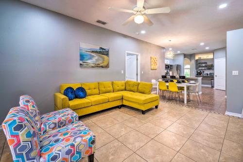 a living room with a yellow couch and a dining room at Sunny Clermont Retreat with Lanai 12 Mi to Disney! in Orlando